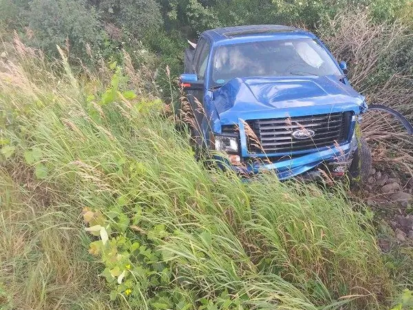 Pickup in tall grass awaiting recovery
