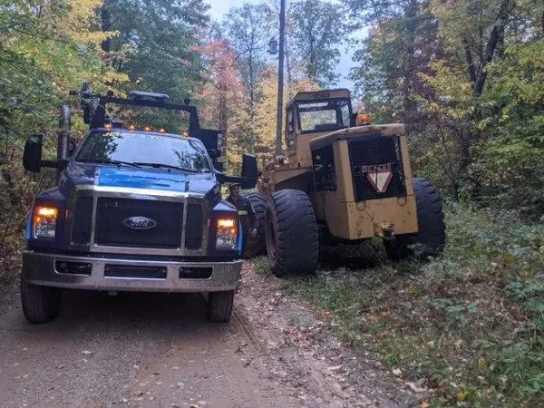 Service truck beside a disabled loader on a two-track