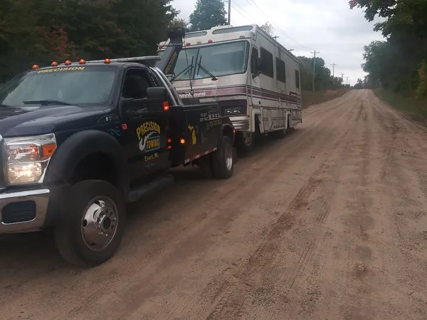 Motorhome towed by a Precision Towing wrecker