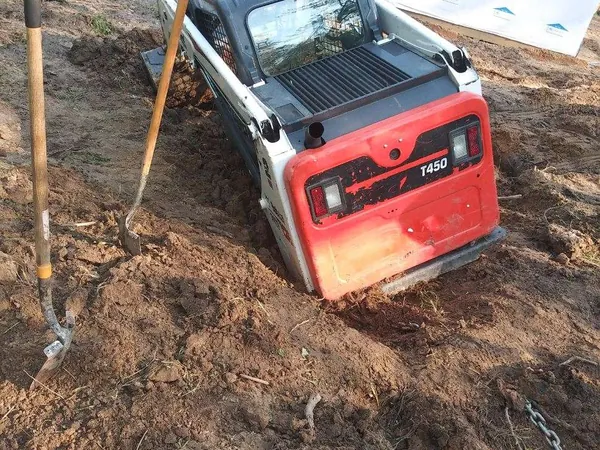 Overturned skid steer before recovery