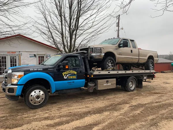 Pickup loaded on a rollback in a residential driveway