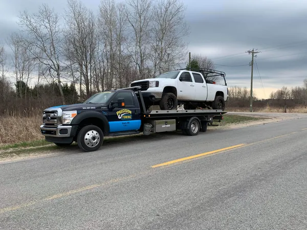 Pickup towed on a rollback along a Michigan highway
