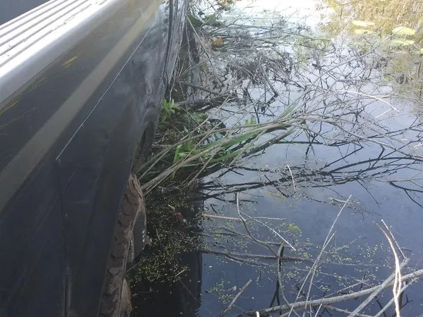 Vehicle in a water-filled ditch