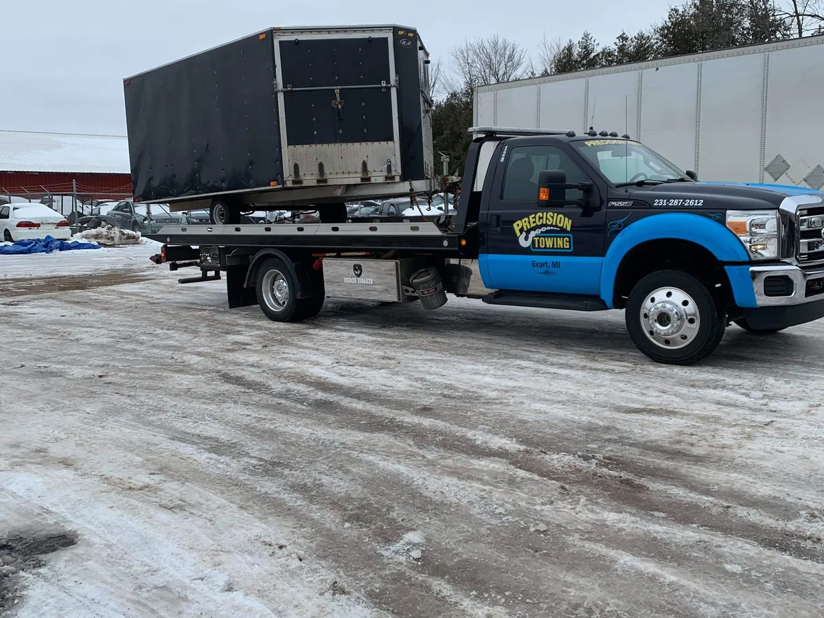 Enclosed cargo trailer on a Precision Towing rollback