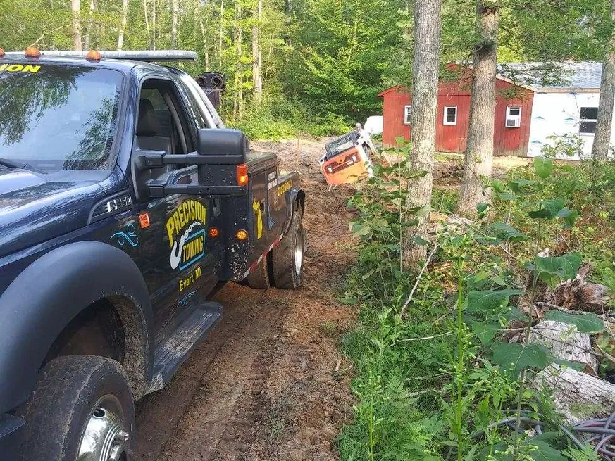 Precision Towing wrecker recovering equipment in the woods