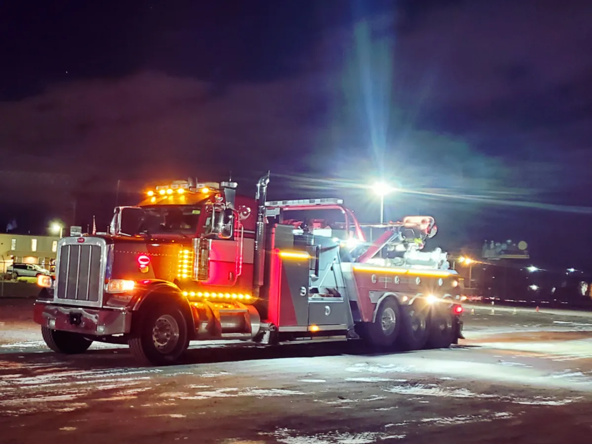 Heavy-duty wrecker lit up for a night-time recovery